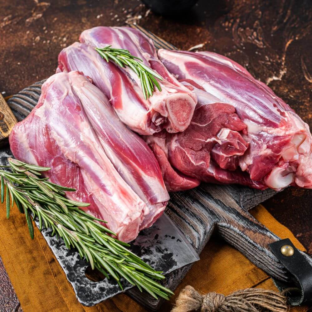 Karoo Lamb shanks raw on a board and knife
